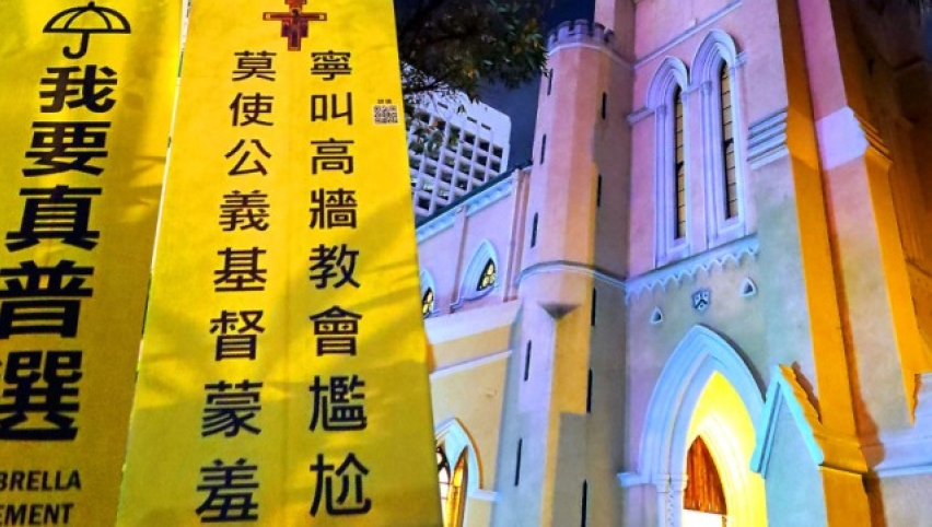 靜坐人士在香港中環聖約翰座堂對出草地掛起的標語。